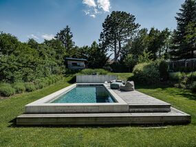 Pool aus Beton in grüer Landschaft